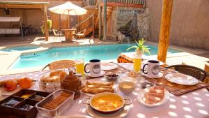 圣佩德罗·德·阿塔卡马何塞之家旅馆的池畔餐桌上摆着早餐食品