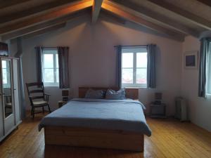 奥德米拉Romantic riverside retreat的一间卧室设有一张大床和两个窗户。