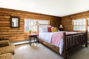 伍德斯托克克德龙山谷宾馆的一间卧室设有木墙、一张床和镜子