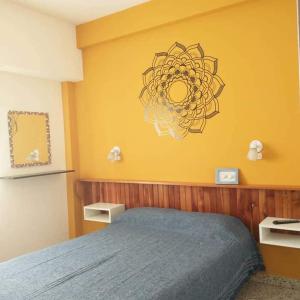 蒙特埃莫索Hostería Altea的一间卧室设有蓝色的床和黄色的墙壁