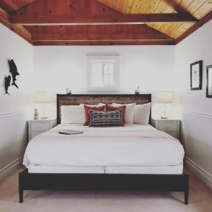 巴港Sand Bar Cottage Inn的卧室配有一张白色大床和木制天花板