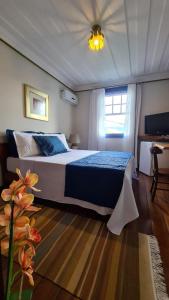 欧鲁普雷图波萨达格兰德之家旅馆的一间卧室配有一张特大号床和天花板