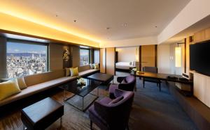 大阪大阪日航国际酒店的一间配备有沙发及电视的酒店客房