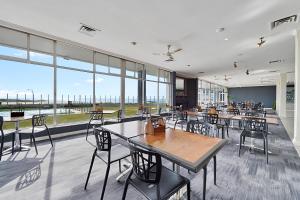斯卡曼德Scamander Beach Resort的餐厅设有桌椅和大窗户。