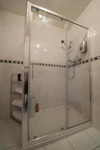 格拉斯哥伯恩赛德酒店的浴室里设有玻璃门淋浴