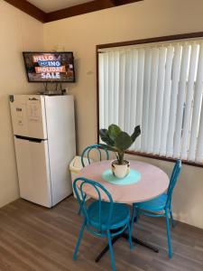 DarawankAdventureland Cabins的厨房配有桌椅和冰箱。