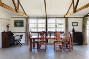 纳纽基Dream the Days away by Yourhost The Rustic Barn Nanyuki Kenya的一间带木桌和椅子的用餐室