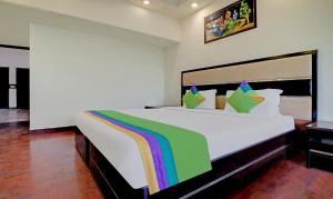 钱德加尔Itsy By Treebo - Southend的卧室配有一张带彩虹的大型白色床