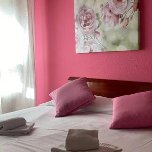 索里亚圣安德烈斯旅馆的卧室拥有粉红色的墙壁,配有一张带粉红色枕头的床