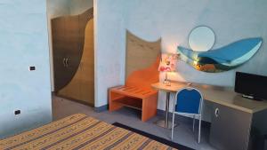 玛格丽塔萨沃亚Hotel Del Sole的一间卧室配有书桌和一张带镜子的床