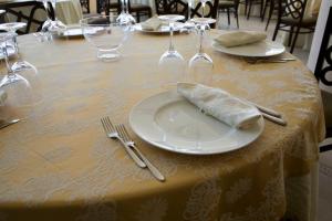 玛格丽塔萨沃亚Hotel Del Sole的一张桌子,上面有带餐巾的白色盘子
