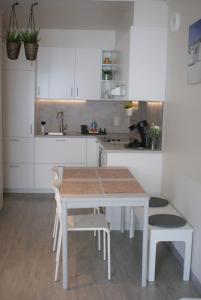 奥斯坦德Sea Side的白色的厨房配有桌椅和水槽