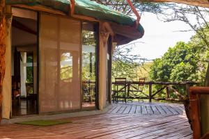 塔勒克PrideInn Mara Camp & Cottages的一个带木甲板的房子的门廊