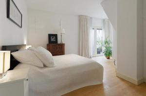 阿姆斯特丹Luxury Prinsengracht Canal House Jordan Area的白色的卧室设有白色的床和窗户。