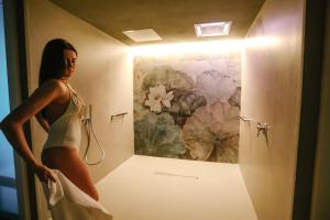 内伊韦朗格乡村别墅住宿加早餐旅馆的女人站在带绘画的浴室里