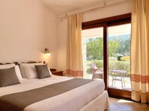 阿尔扎凯纳Punta D'Acu Country Resort的一间卧室设有一张床和一个滑动玻璃门