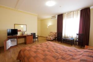 梁赞Hotel Odisseya的酒店客房设有一间带一张床和电视的卧室