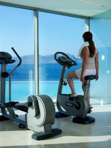 林都斯Lindos Blu Luxury Hotel-Adults only的一名在健身房骑健身自行车的女子