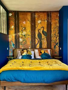 锡河边的圣奥班Aux Jolies Sources的卧室配有一张大床,墙上挂有绘画作品