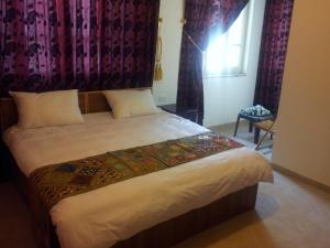 安曼约旦河酒店的一间卧室设有一张大床和窗户