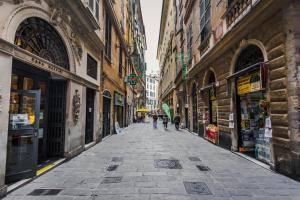 热那亚迷你酒店的一条小巷,人们沿着街道漫步,街道上有许多建筑