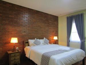 马格朗Nia Maretta House Syariah的一间卧室设有一张床和砖墙