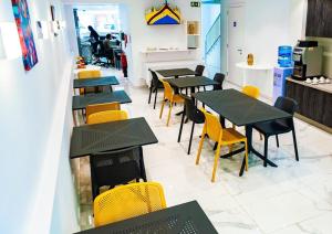圣朱利安斯Hotel Shoreline的用餐室配有桌子和黄色椅子
