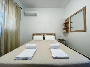阿彻奇洛斯Archangelos Garden House的一间卧室配有一张带两个枕头的床