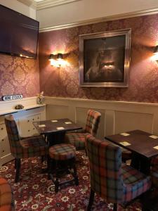 布莱克浦The Woodleigh family hotel的一间带桌椅的餐厅以及墙上的电视