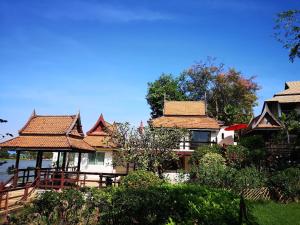 Ban Bang Krasan大城府河畔景苑酒店的一组房屋,屋顶铺有瓷砖