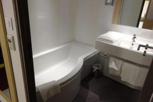 马拉科夫巴黎马拉科夫查狄伦公寓式酒店的带浴缸和盥洗盆的浴室