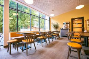 代特莫尔德代特莫尔德青年旅舍的餐厅设有桌椅和大窗户。