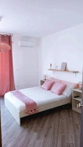 巴勒莫DIMENTICA IL CERVELLO的一间卧室配有带粉红色枕头的床。