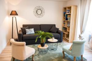莱萨布勒-多洛讷海洋公寓酒店的客厅配有沙发和两把椅子