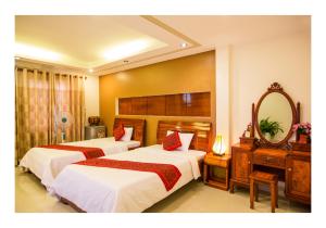 会安Hoang Thu Hostel的酒店客房,设有两张床和镜子