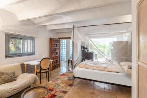 马略卡岛帕尔马Pool House的一间卧室配有一张床、一张沙发和一张桌子