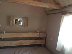 博恩瑟Sivagerhuset Holiday-Home的一间卧室配有一张带木制床头板的床和窗户。