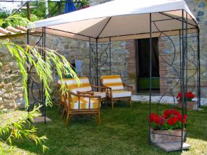Sasso PisanoApartment Stalla by Interhome的白色遮阳伞下的桌椅