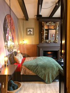 弗利辛恩Slapen bij Café de Concurrent的一间卧室配有一张床、镜子和壁炉