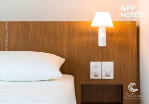 萨利诺波利斯SALINAS EXCLUSIVE - GAV Resorts的一间卧室配有一张床,墙上有灯