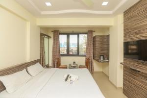 孟买Hotel Mid town的一间卧室设有一张床和一个大窗户