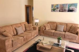 布尔高BURGUNA Apartment, 500m from Burgau Beach的客厅配有2张棕色沙发和1张桌子