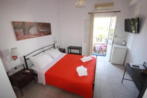 普拉提伊亚洛斯西弗诺斯基克拉泽斯海滩公寓式酒店的一间卧室配有一张带红色毯子的床
