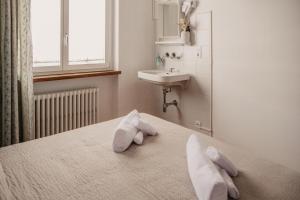 维拉里瓦宾馆的一间卧室配有水槽和一张带毛巾的床