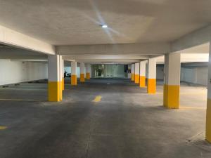 瓜达拉哈拉Motel Casablanca的空停车场里有一个空的停车位,里面装有黄色柱子