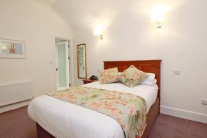 都柏林Harry Clarke Mews at the Castle Hotel的一间卧室配有带白色床单和枕头的床。