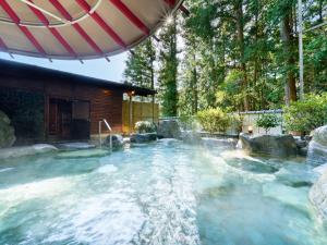 下吕市Yukai Resort Gero Saichoraku Bekkan的房屋后院的热水浴池