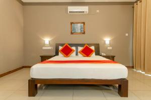 康提Kings Ridge Kandy的一间卧室配有一张大床和两个橙色枕头