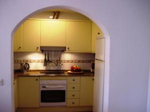 科拉雷侯Lovely CottageAurora的厨房内的拱门,配有炉灶和冰箱