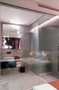 胡志明市标志精品酒店的一间带玻璃淋浴和水槽的浴室